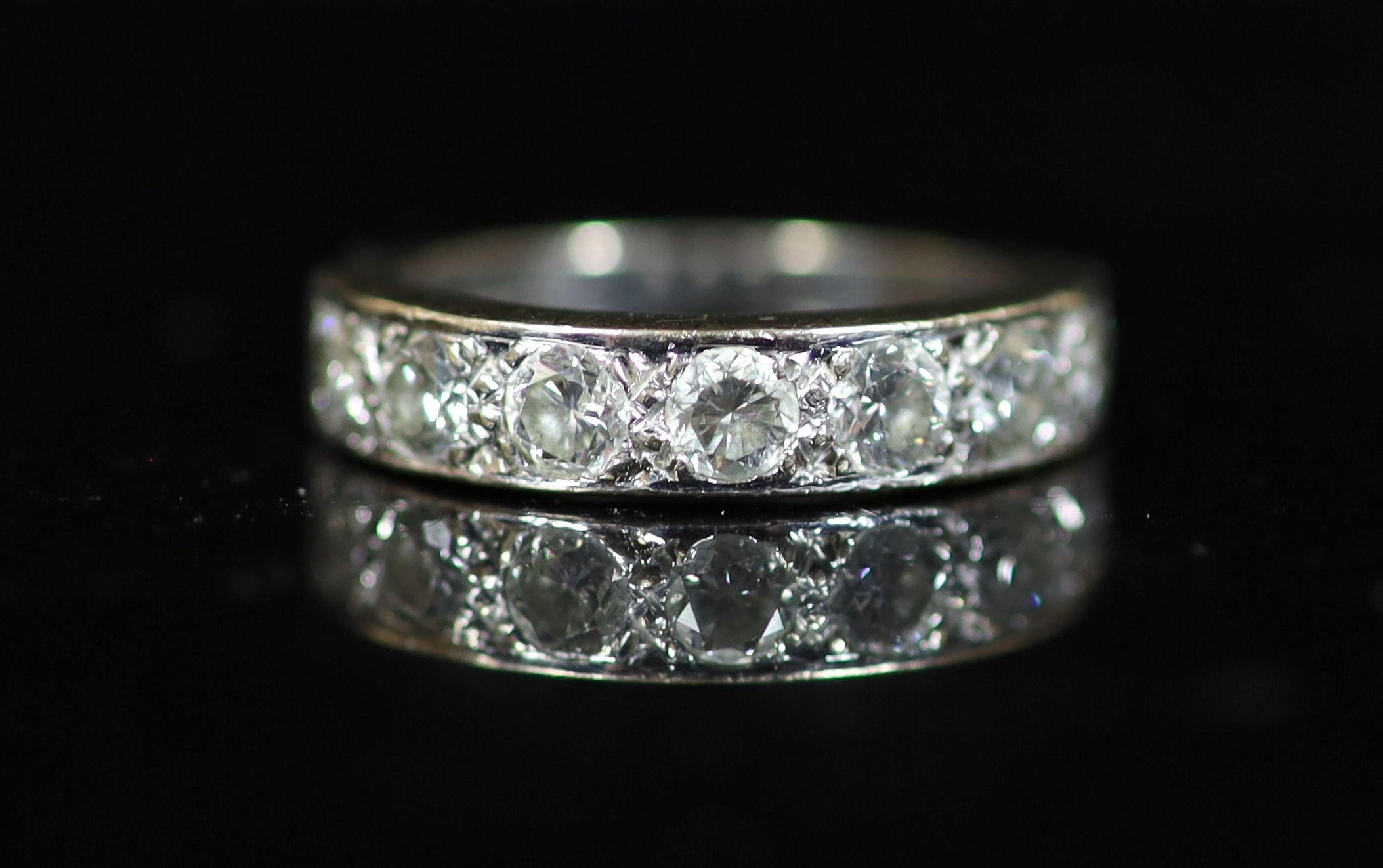 A modern white gold and channel set seven stone diamond half hoop ring
